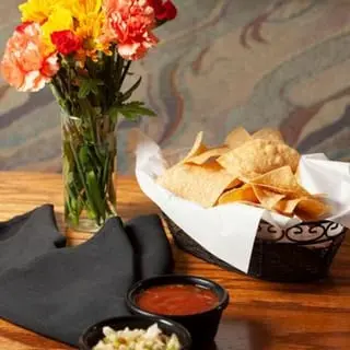 Chips and salsa served beside fresh flowers